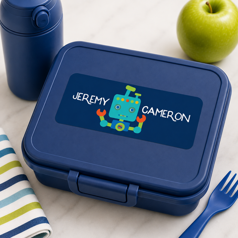 Personalized robot waterproof name label on a navy blue lunch box with matching solid blue water bottle and coordinating school lunch accessories.