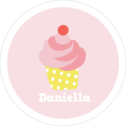 Personalized cupcake waterproof name label on a pastel pink lunch box with matching pink water bottle, cupcake-themed accessories, and coordinated pastel props.